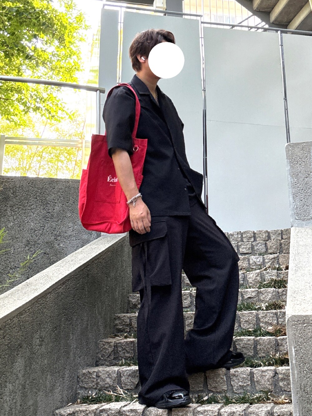 ブラック系のカーゴパンツ、レッド系のトートバッグ、ブラック系のシャツ/ブラウスを着用したメンズの秋コーディネートの2枚目の写真