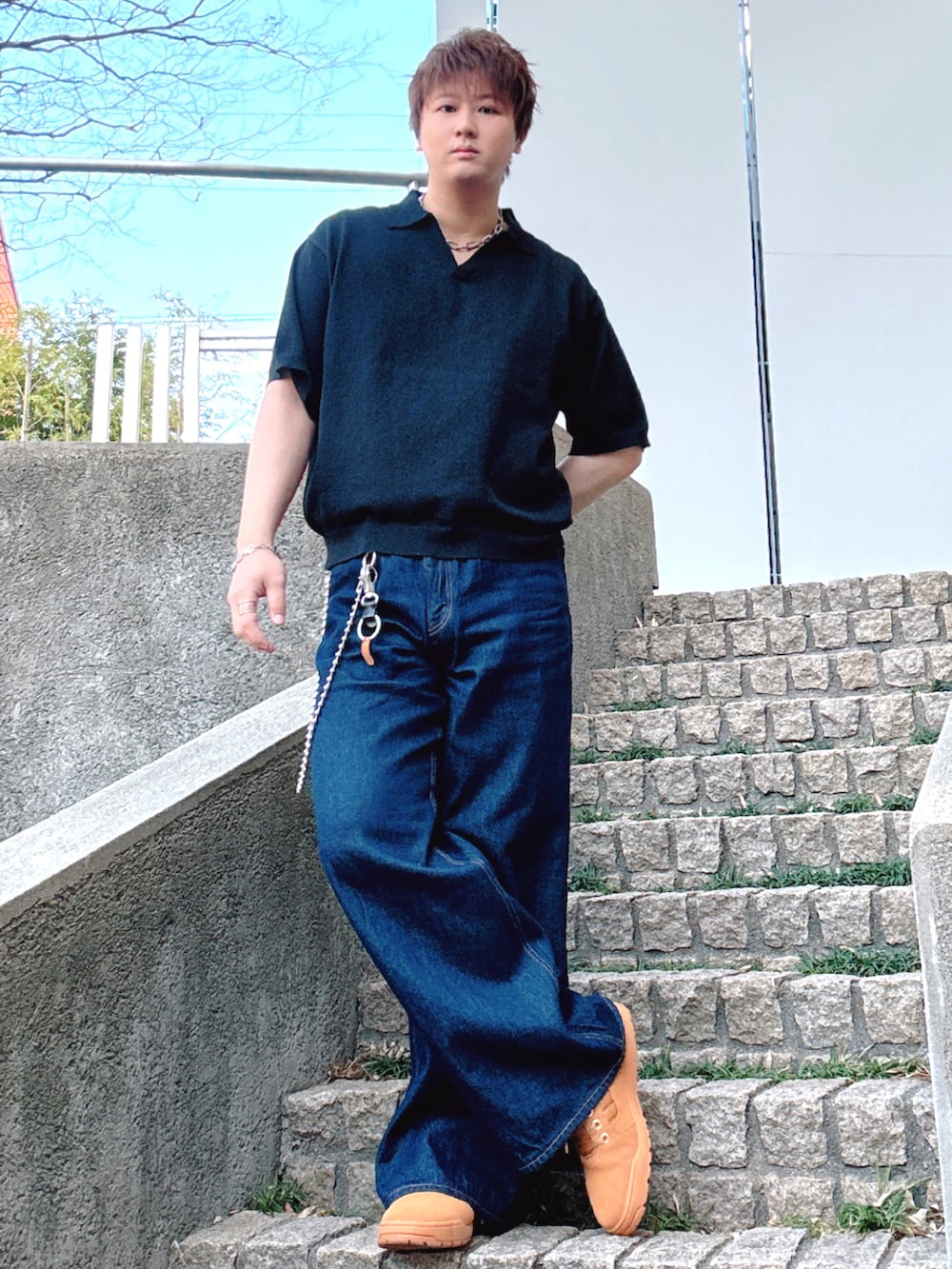 ブルー系のデニムパンツ、イエロー系のスニーカーを着用したメンズの春コーディネートの2枚目の写真
