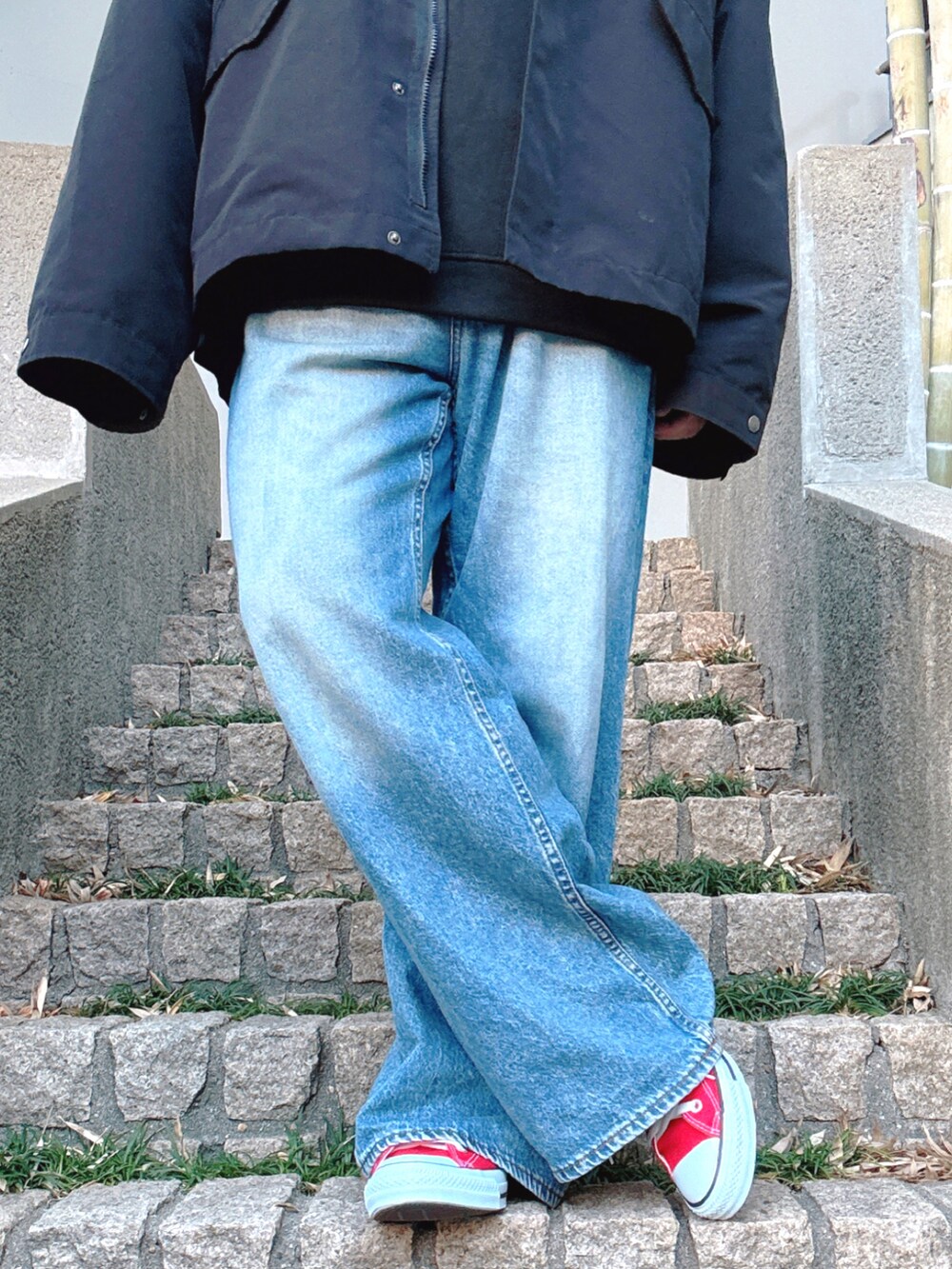 ブルー系のデニムパンツ、レッド系のスニーカー、ブラック系のブルゾンを着用したメンズの冬コーディネートの5枚目の写真