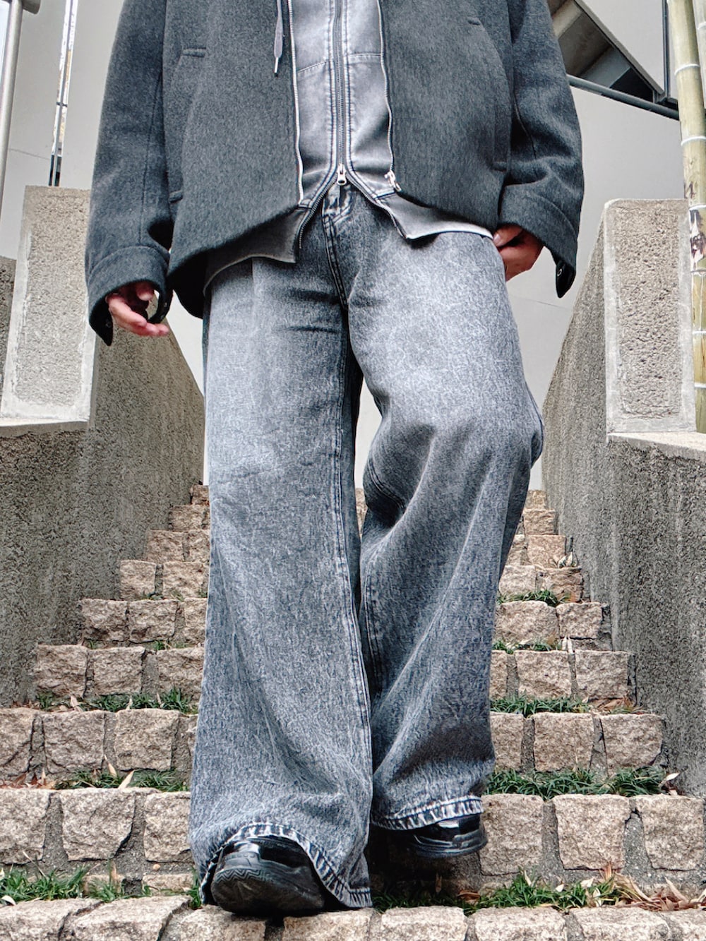 グレー系のその他アウター、ブラック系のデニムパンツ、ブラック系のその他シューズを着用したメンズの冬コーディネートの5枚目の写真