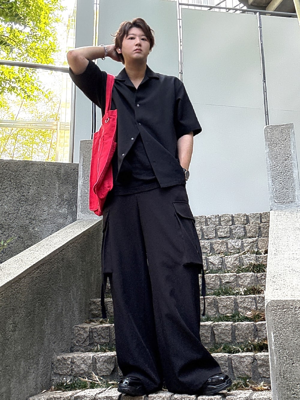 ブラック系のカーゴパンツ、レッド系のトートバッグ、ブラック系のシャツ/ブラウスを着用したメンズの秋コーディネートの3枚目の写真