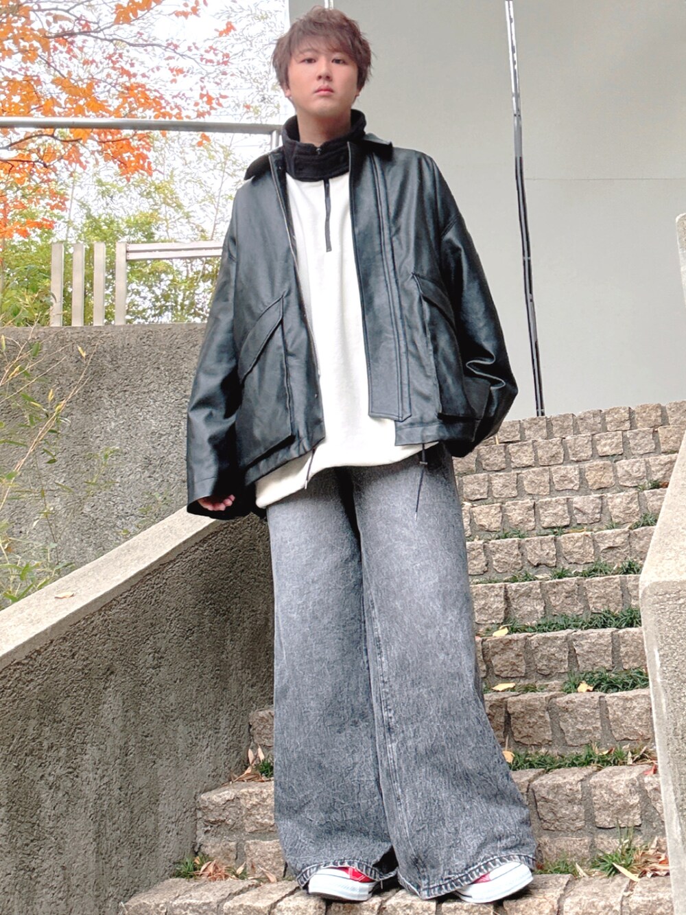 レッド系のスニーカー、ブラック系のデニムパンツ、ブラック系のブルゾンを着用したメンズの冬コーディネートの3枚目の写真