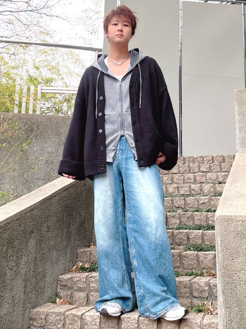 ブルー系のデニムパンツ、グレー系のスニーカー、ブラック系のカーディガン/ボレロを着用したメンズの冬コーディネートの2枚目の写真