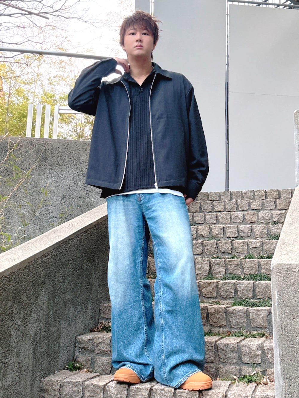 ブルー系のデニムパンツ、ブラック系のブルゾン、イエロー系のスニーカーを着用したメンズの冬コーディネートの3枚目の写真