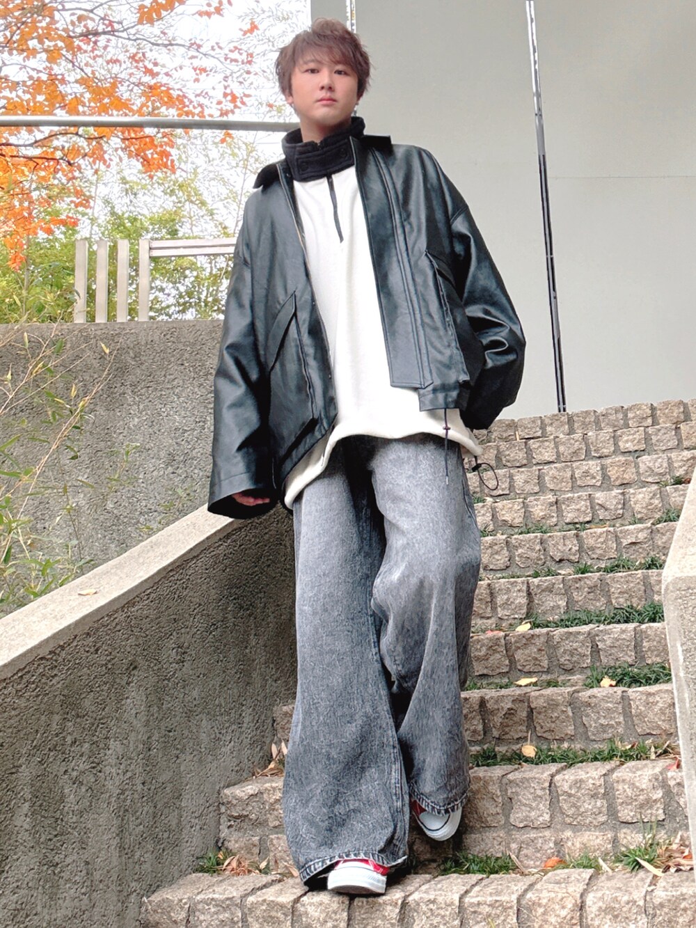 レッド系のスニーカー、ブラック系のデニムパンツ、ブラック系のブルゾンを着用したメンズの冬コーディネートの2枚目の写真
