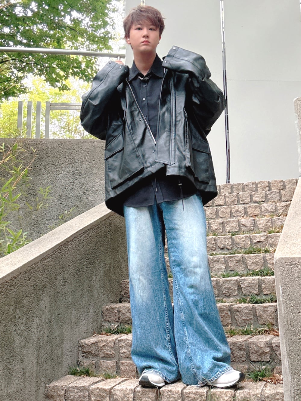 ブルー系のデニムパンツ、グレー系のスニーカー、ブラック系のブルゾンを着用したメンズの秋コーディネートの3枚目の写真