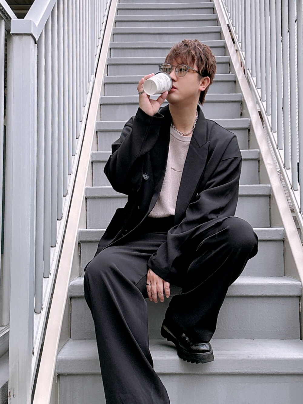 ブラック系のセットアップ、ベージュ系のTシャツ/カットソー、ブラック系のドレスシューズを着用したメンズの春コーディネートの2枚目の写真