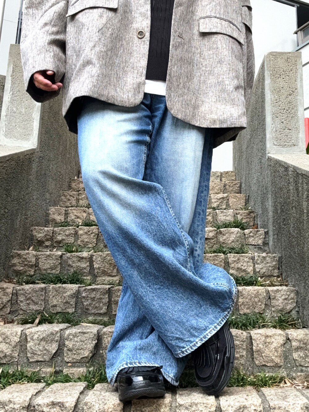 ベージュ系のテーラードジャケット、ブルー系のデニムパンツ、ブラック系のその他シューズを着用したメンズの春コーディネートの5枚目の写真