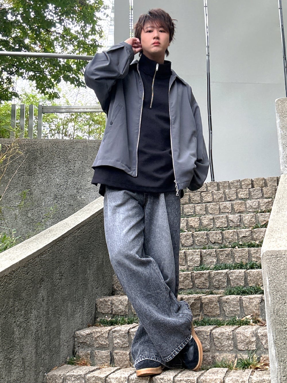 ブラック系のデニムパンツ、ブラック系のTシャツ/カットソー、グレー系のブルゾンを着用したメンズの秋コーディネートの2枚目の写真