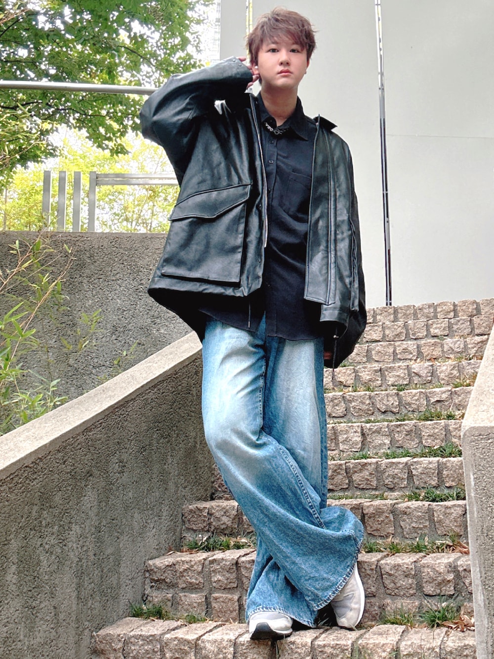 ブルー系のデニムパンツ、グレー系のスニーカー、ブラック系のブルゾンを着用したメンズの秋コーディネートの2枚目の写真