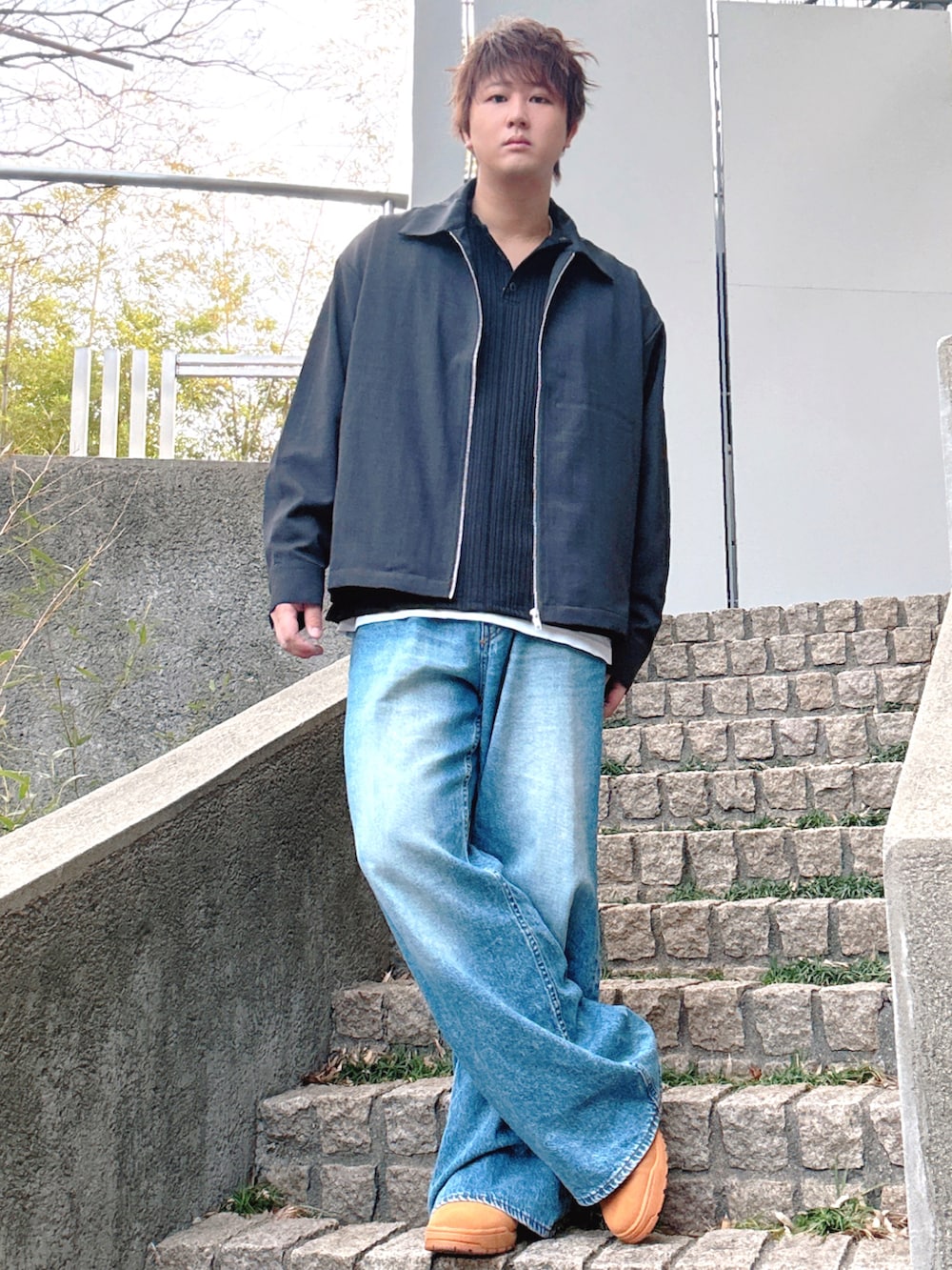 ブルー系のデニムパンツ、ブラック系のブルゾン、イエロー系のスニーカーを着用したメンズの冬コーディネートの2枚目の写真
