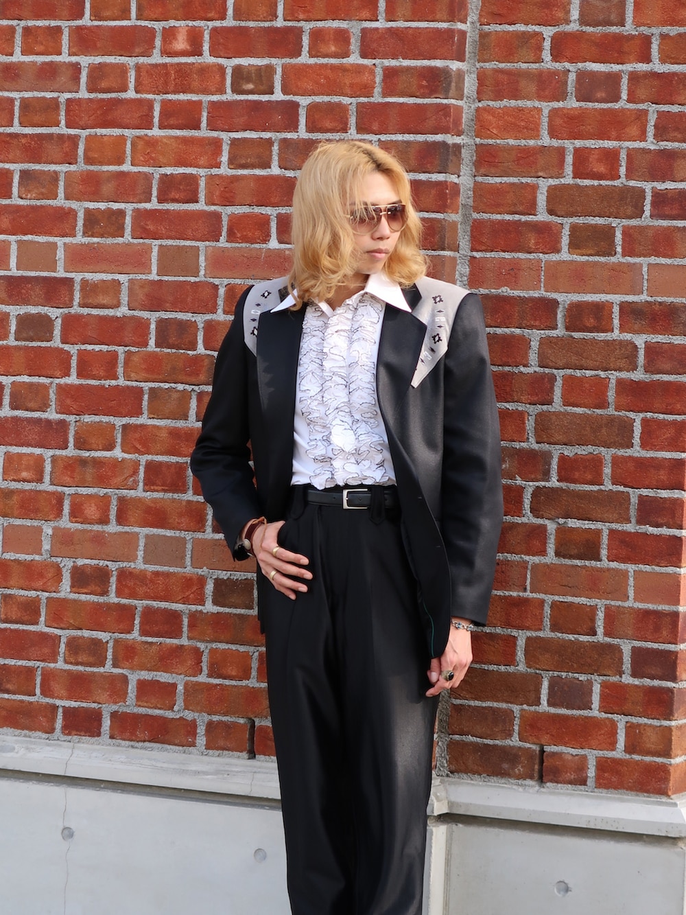 ブラック系のスラックス、ブラック系のブーツ、ブラック系のテーラードジャケットを着用したメンズの春コーディネートの2枚目の写真