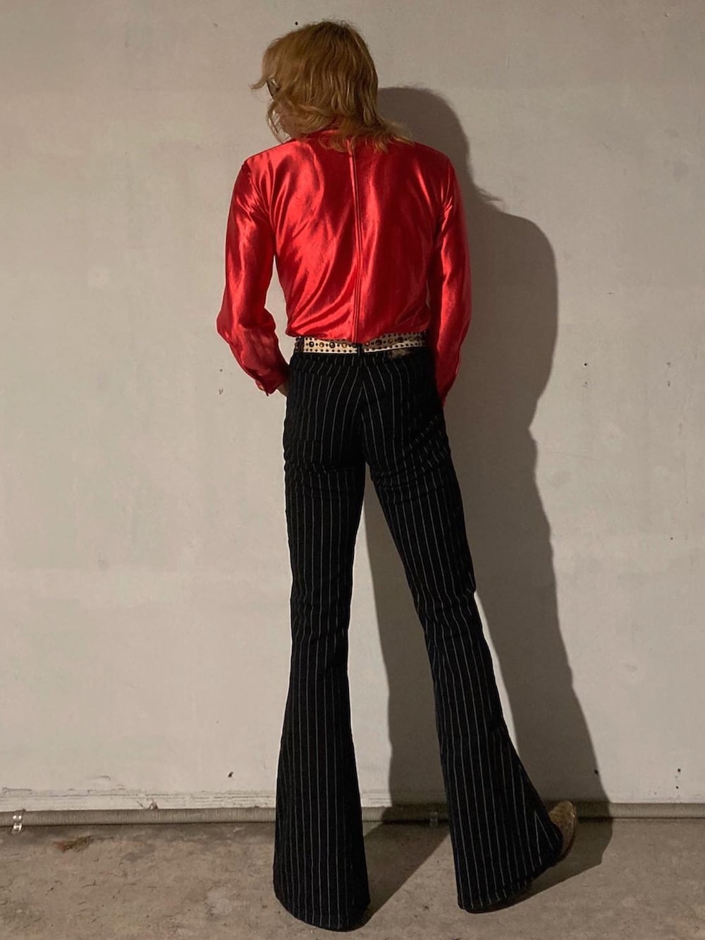 ブラック系のスラックス、ベージュ系のブーツ、レッド系のシャツ/ブラウスを着用したメンズの秋コーディネートの2枚目の写真