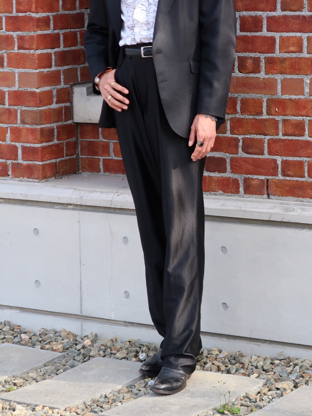 ブラック系のスラックス、ブラック系のブーツ、ブラック系のテーラードジャケットを着用したメンズの春コーディネートの3枚目の写真