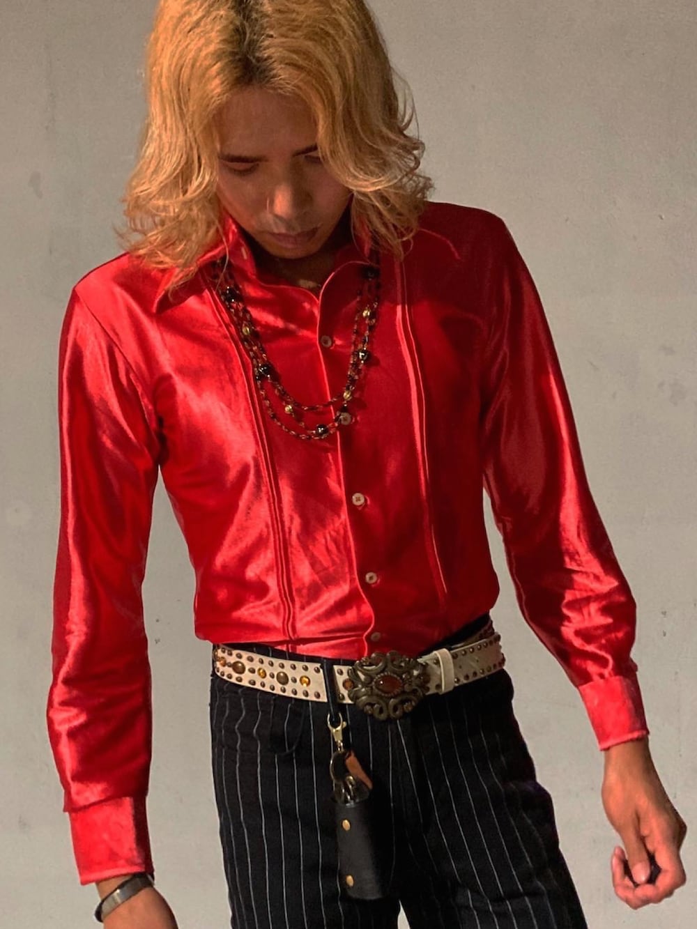 ブラック系のスラックス、ベージュ系のブーツ、レッド系のシャツ/ブラウスを着用したメンズの秋コーディネートの4枚目の写真