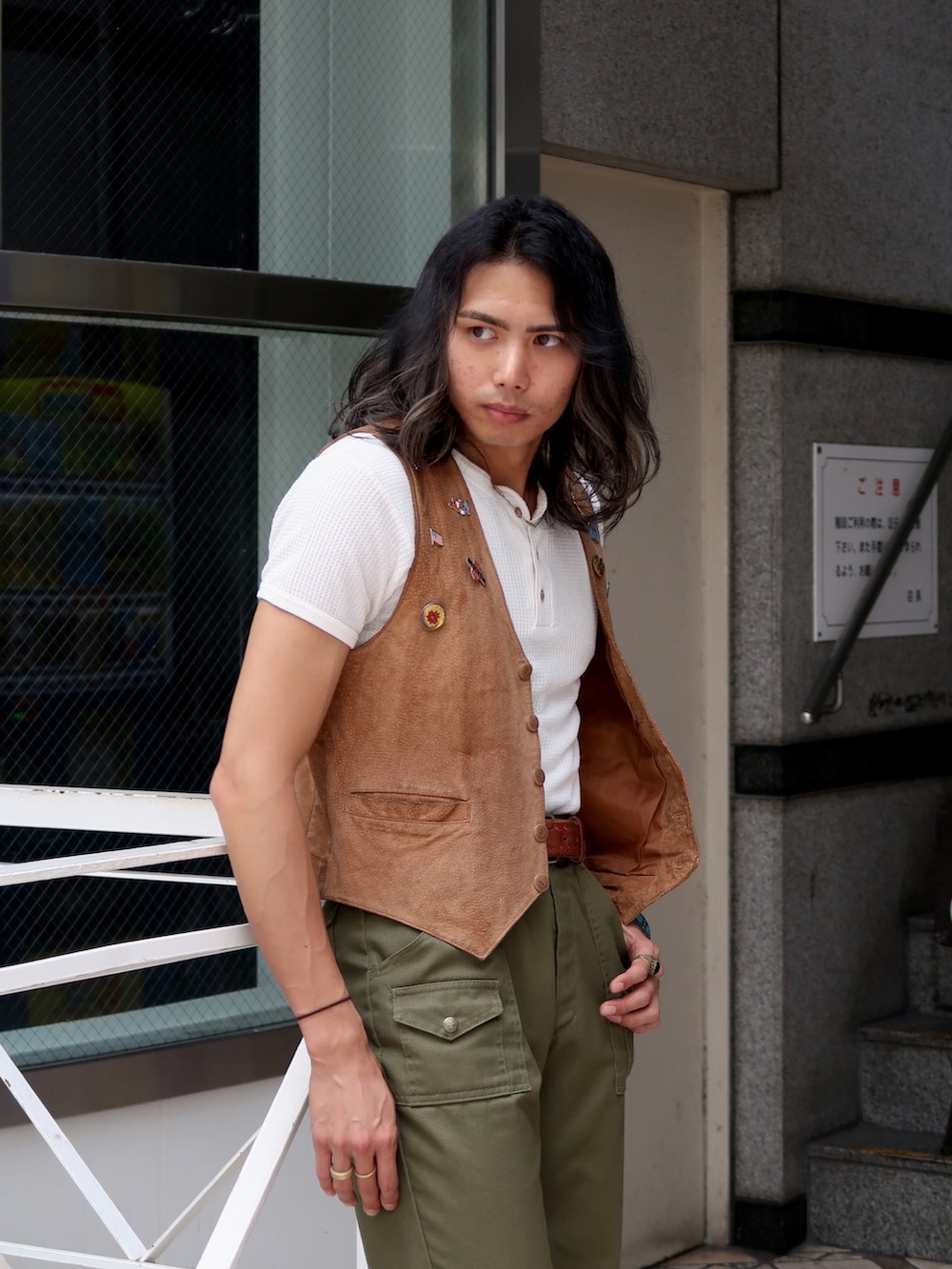 グリーン系のスラックス、ホワイト系のTシャツ/カットソー、ブラウン系のブーツを着用したメンズの夏コーディネートの2枚目の写真