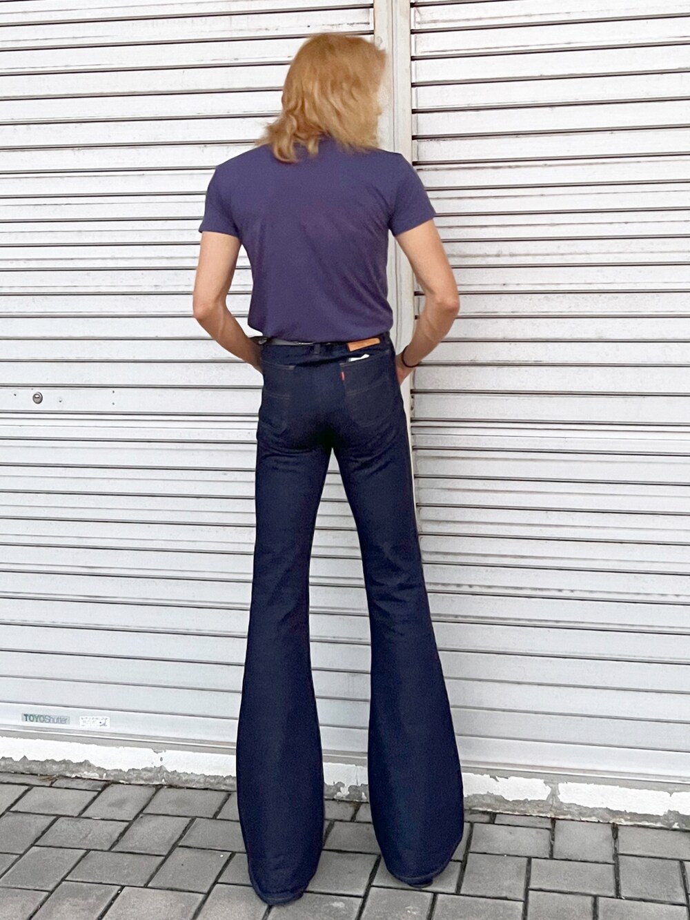 ブルー系のデニムパンツ、パープル系のTシャツ/カットソー、ブラック系のブーツを着用したメンズの夏コーディネートの2枚目の写真