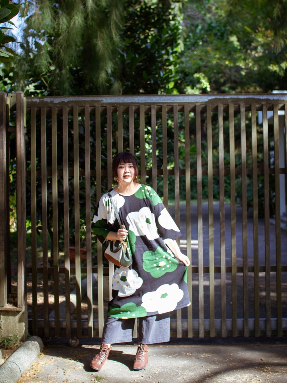 ブラウン系のムートンコート、ブラック系のワンピース、その他のトートバッグを着用したレディースの夏コーディネートの4枚目の写真