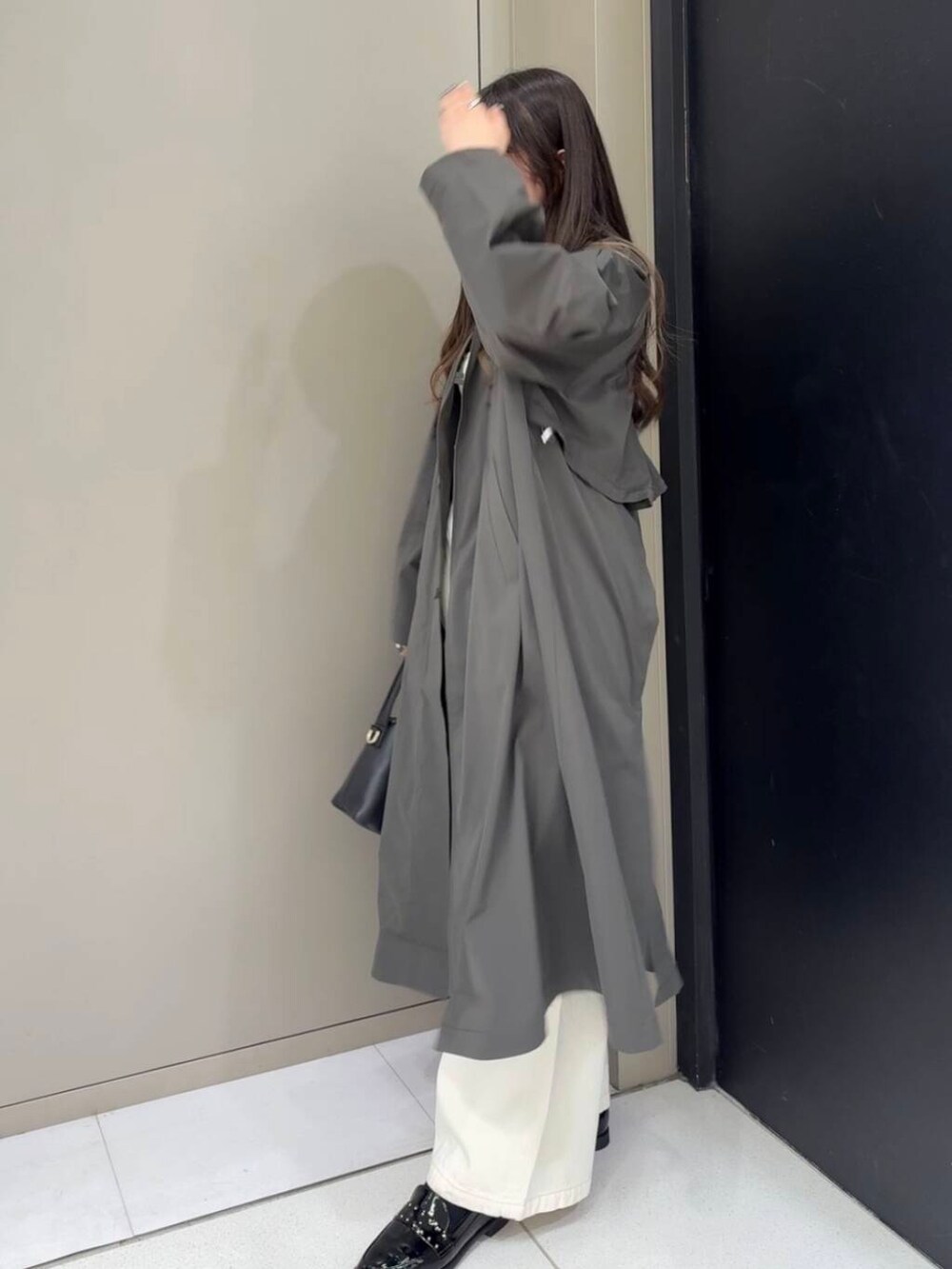 ブラック系のローファー、ホワイト系のベスト、ホワイト系のデニムパンツを着用したレディースの冬コーディネートの3枚目の写真