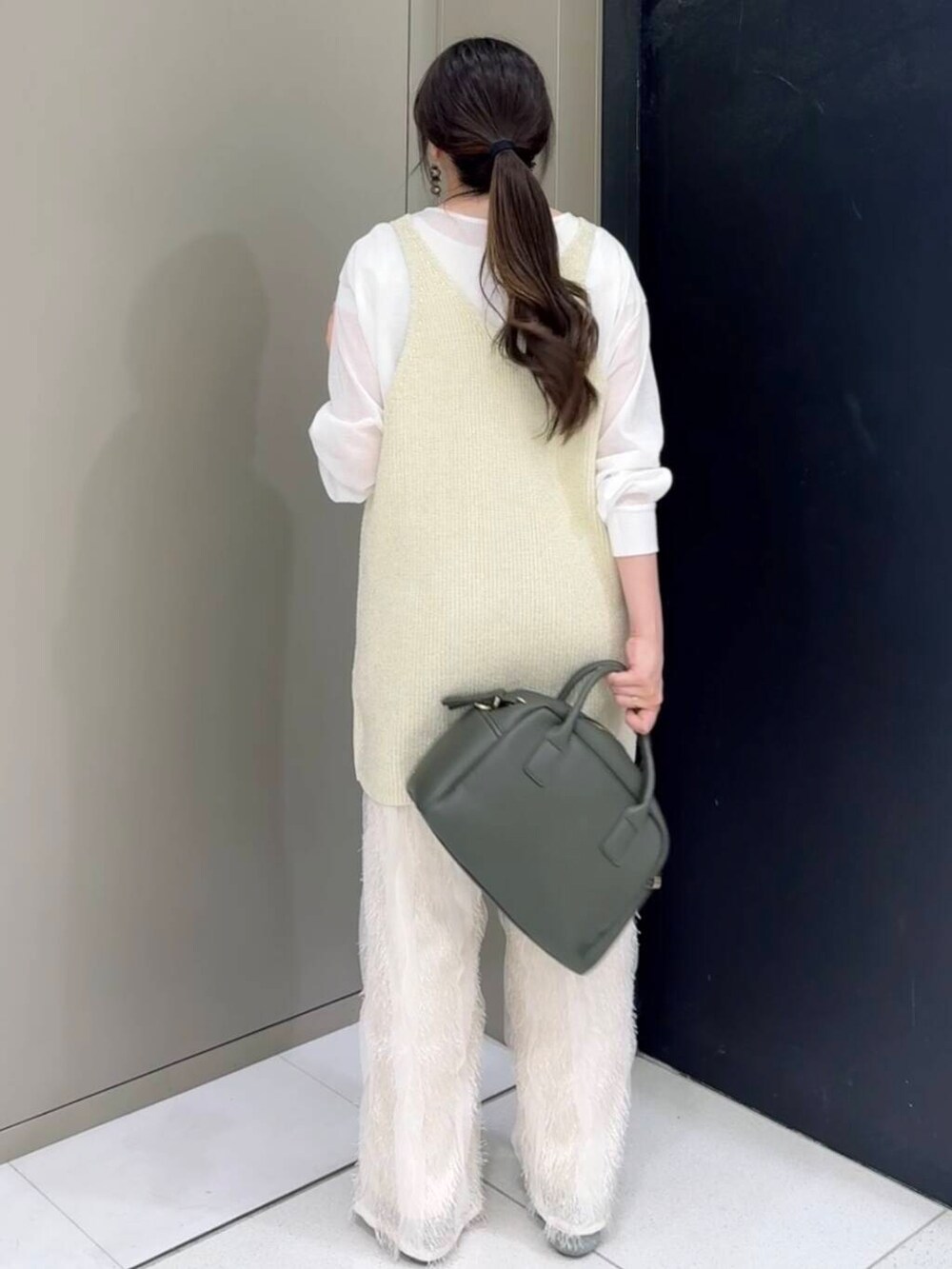 グリーン系のボストンバッグ、ホワイト系のその他パンツ、ホワイト系のニット/セーターを着用したレディースの秋コーディネートの4枚目の写真