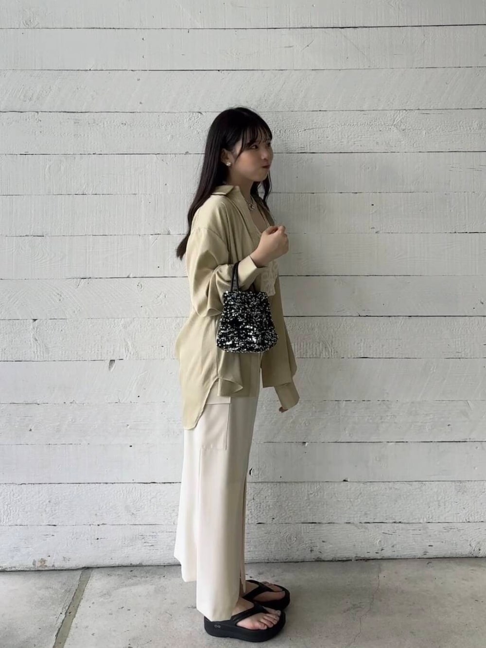 シルバー系のショルダーバッグ、ベージュ系のシャツ/ブラウス、ホワイト系のベストを着用したレディースの夏コーディネートの3枚目の写真