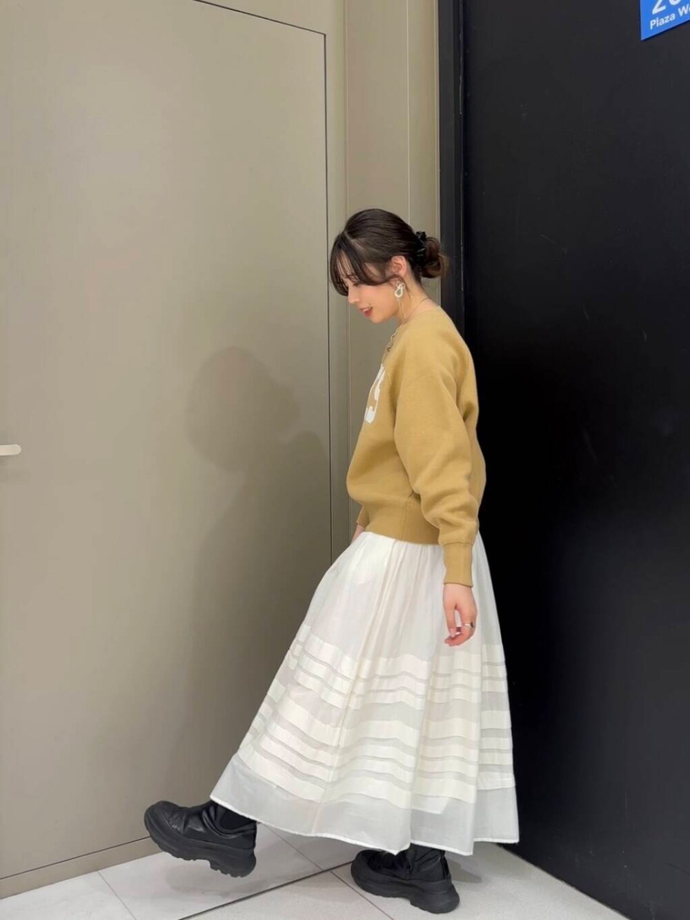 ベージュ系のニット/セーター、ホワイト系のスカート、ブラック系のショルダーバッグを着用したレディースの冬コーディネートの4枚目の写真