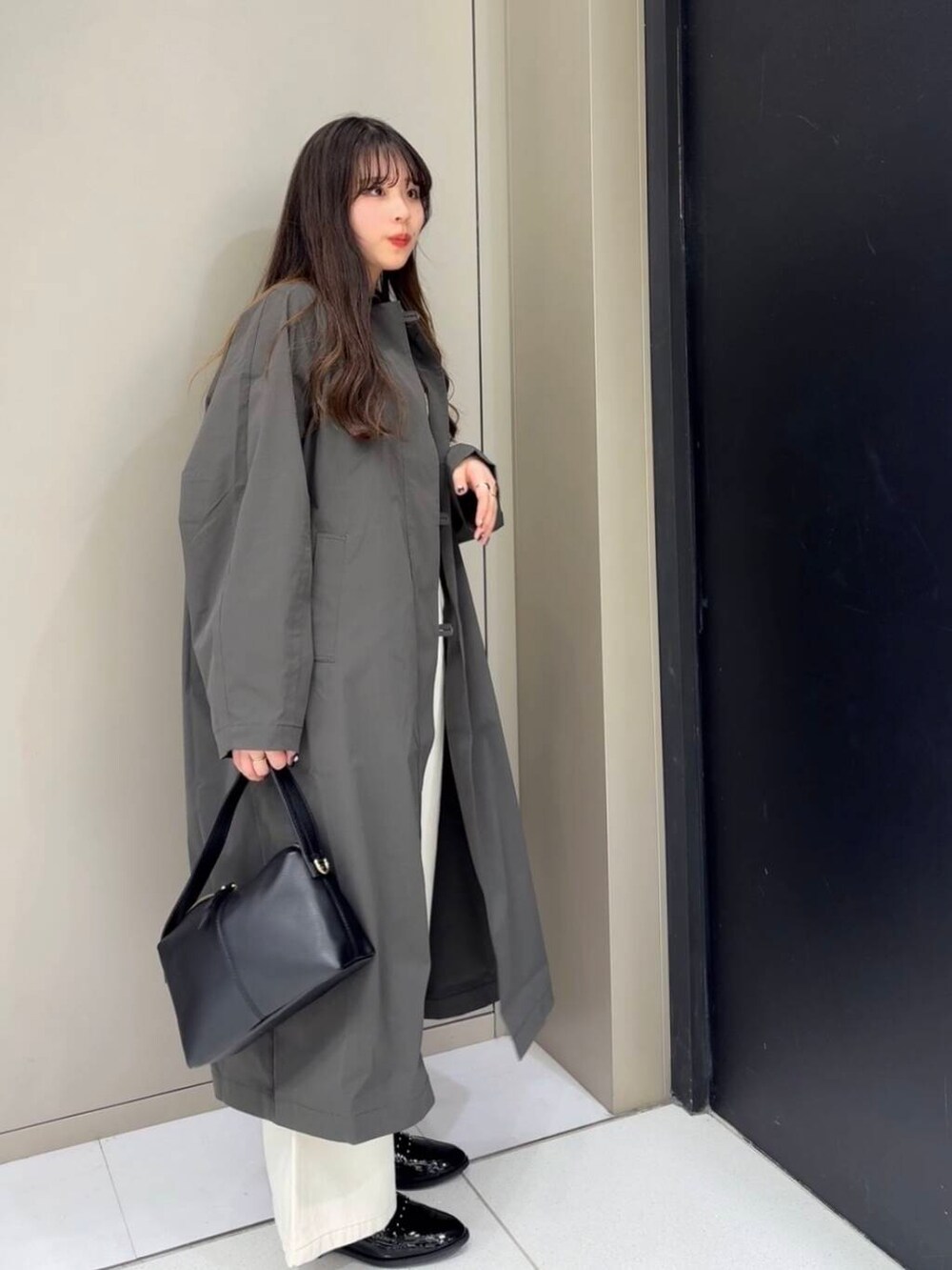 ブラック系のローファー、ホワイト系のベスト、ホワイト系のデニムパンツを着用したレディースの冬コーディネートの4枚目の写真