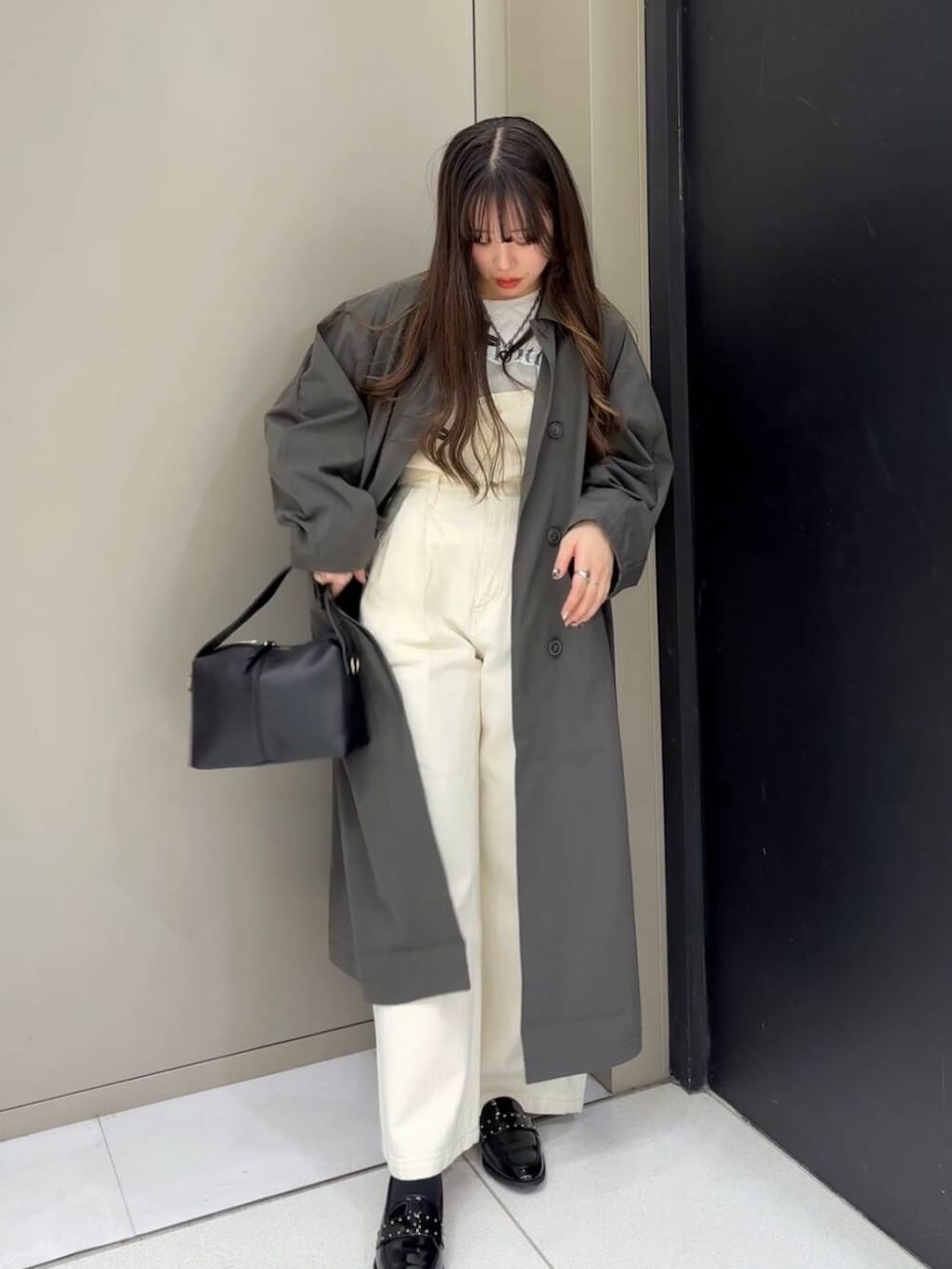 ブラック系のローファー、ホワイト系のベスト、ホワイト系のデニムパンツを着用したレディースの冬コーディネートの7枚目の写真