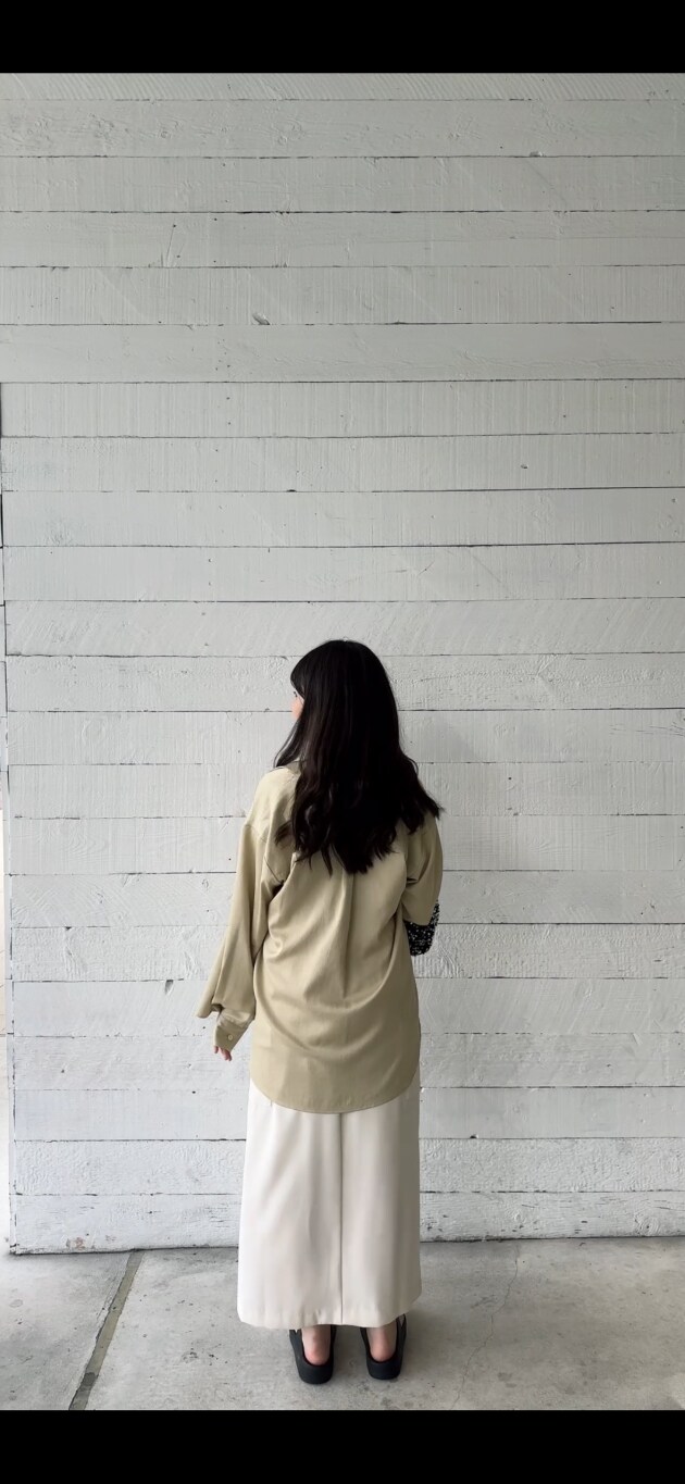 シルバー系のショルダーバッグ、ベージュ系のシャツ/ブラウス、ホワイト系のベストを着用したレディースの夏コーディネートの5枚目の写真