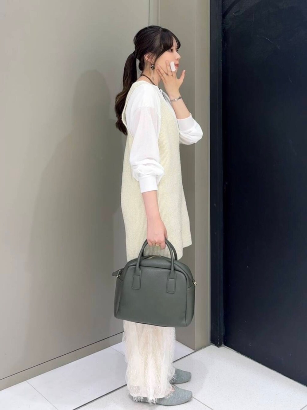 グリーン系のボストンバッグ、ホワイト系のその他パンツ、ホワイト系のニット/セーターを着用したレディースの秋コーディネートの3枚目の写真