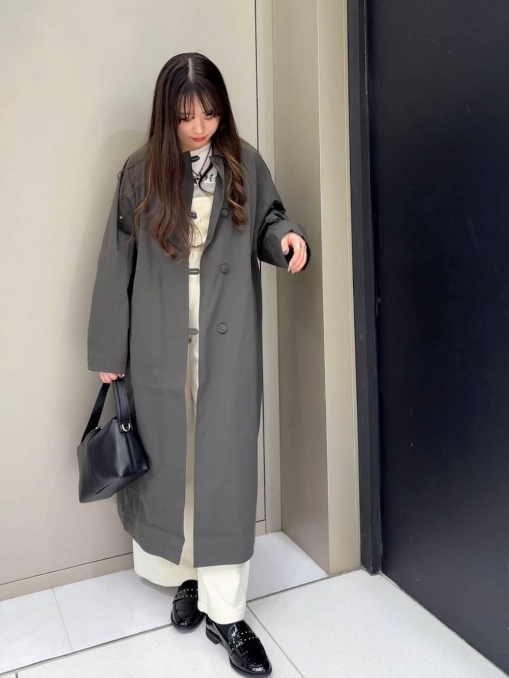 ブラック系のローファー、ホワイト系のベスト、ホワイト系のデニムパンツを着用したレディースの冬コーディネートの5枚目の写真