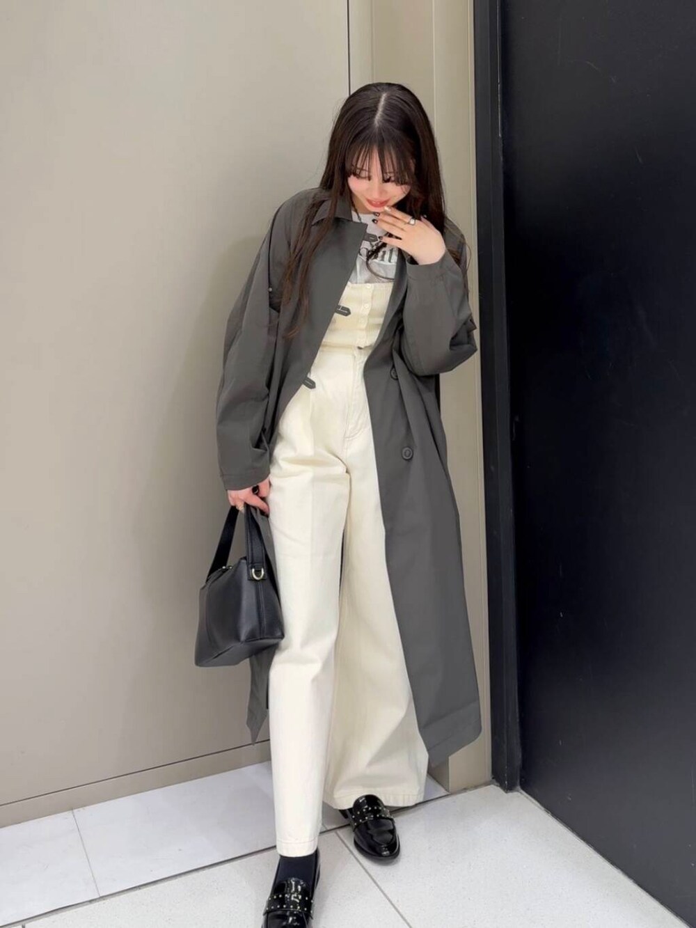 ブラック系のローファー、ホワイト系のベスト、ホワイト系のデニムパンツを着用したレディースの冬コーディネートの2枚目の写真