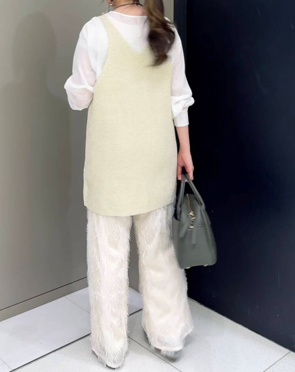 グリーン系のボストンバッグ、ホワイト系のその他パンツ、ホワイト系のニット/セーターを着用したレディースの秋コーディネートの5枚目の写真