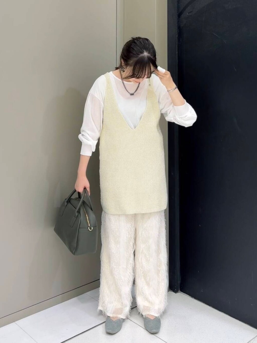 グリーン系のボストンバッグ、ホワイト系のその他パンツ、ホワイト系のニット/セーターを着用したレディースの秋コーディネートの2枚目の写真
