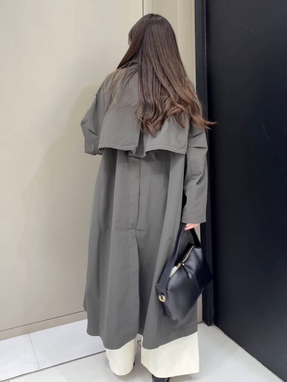 ブラック系のローファー、ホワイト系のベスト、ホワイト系のデニムパンツを着用したレディースの冬コーディネートの6枚目の写真