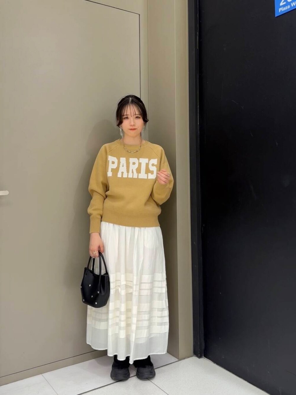 ベージュ系のニット/セーター、ホワイト系のスカート、ブラック系のショルダーバッグを着用したレディースの冬コーディネートの2枚目の写真