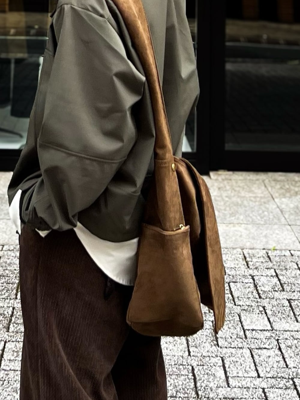 ホワイト系のシャツ/ブラウス、ブラウン系のスラックス、グリーン系のブルゾンを着用したメンズの秋コーディネートの3枚目の写真