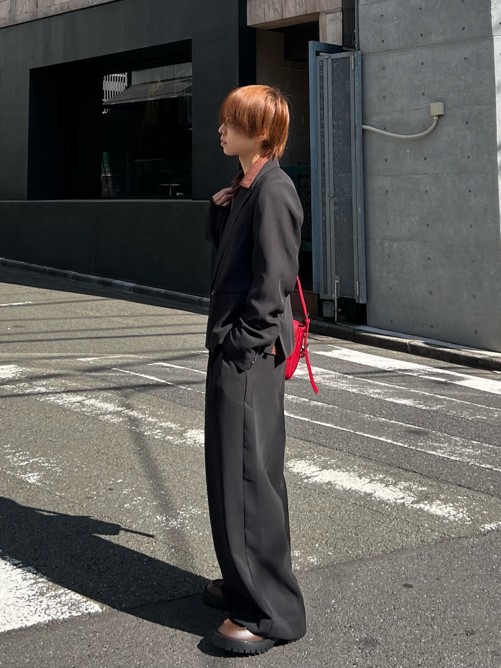 ブラック系のテーラードジャケット、ブラック系のスラックス、ブラウン系のローファーを着用したメンズの冬コーディネートの2枚目の写真