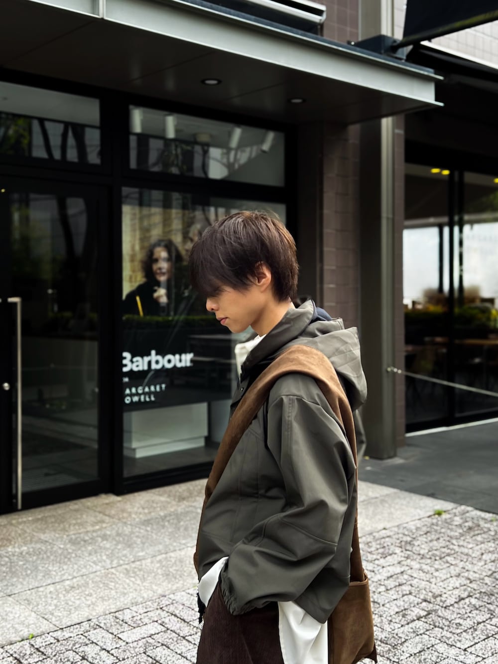 ホワイト系のシャツ/ブラウス、ブラウン系のスラックス、グリーン系のブルゾンを着用したメンズの秋コーディネートの2枚目の写真