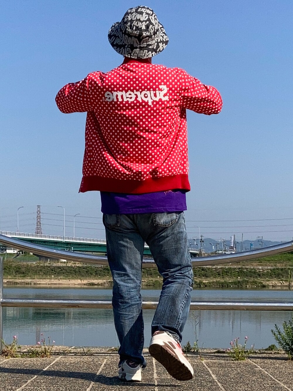 パープル系のTシャツ/カットソー、ブルー系のデニムパンツ、ピンク系のスニーカーを着用したメンズの春コーディネートの2枚目の写真