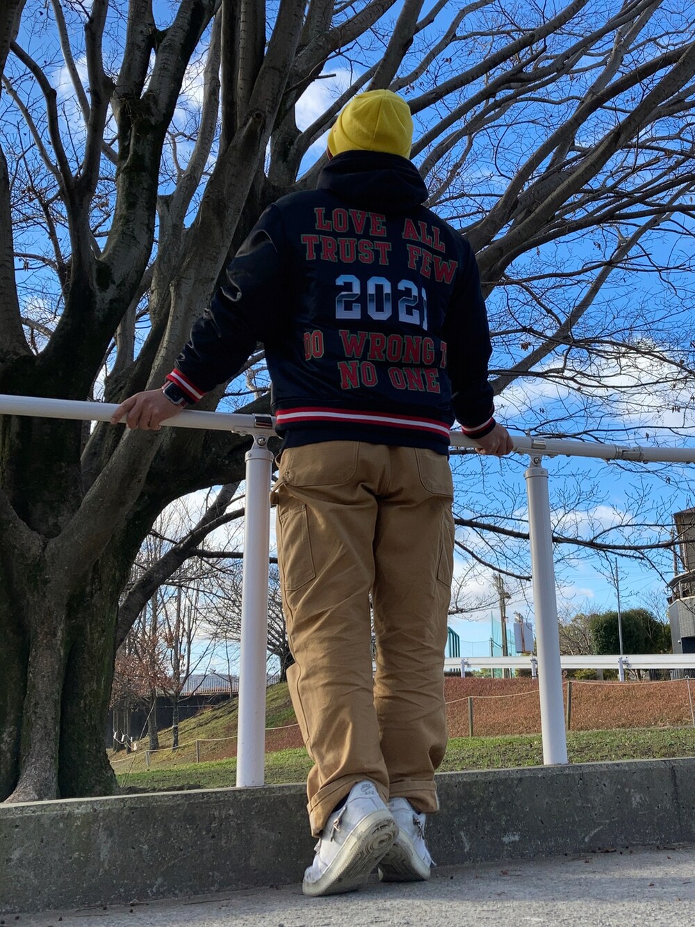 ブラック系のスタジャン、イエロー系のカーゴパンツ、ホワイト系のスニーカーを着用したメンズの冬コーディネートの2枚目の写真