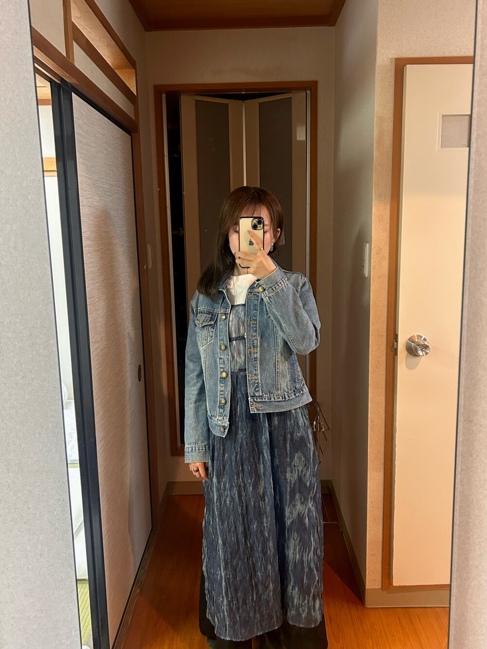 ブルー系のワンピース、ホワイト系のスウェット、ブラック系のスカートを着用したレディースの春コーディネートの2枚目の写真