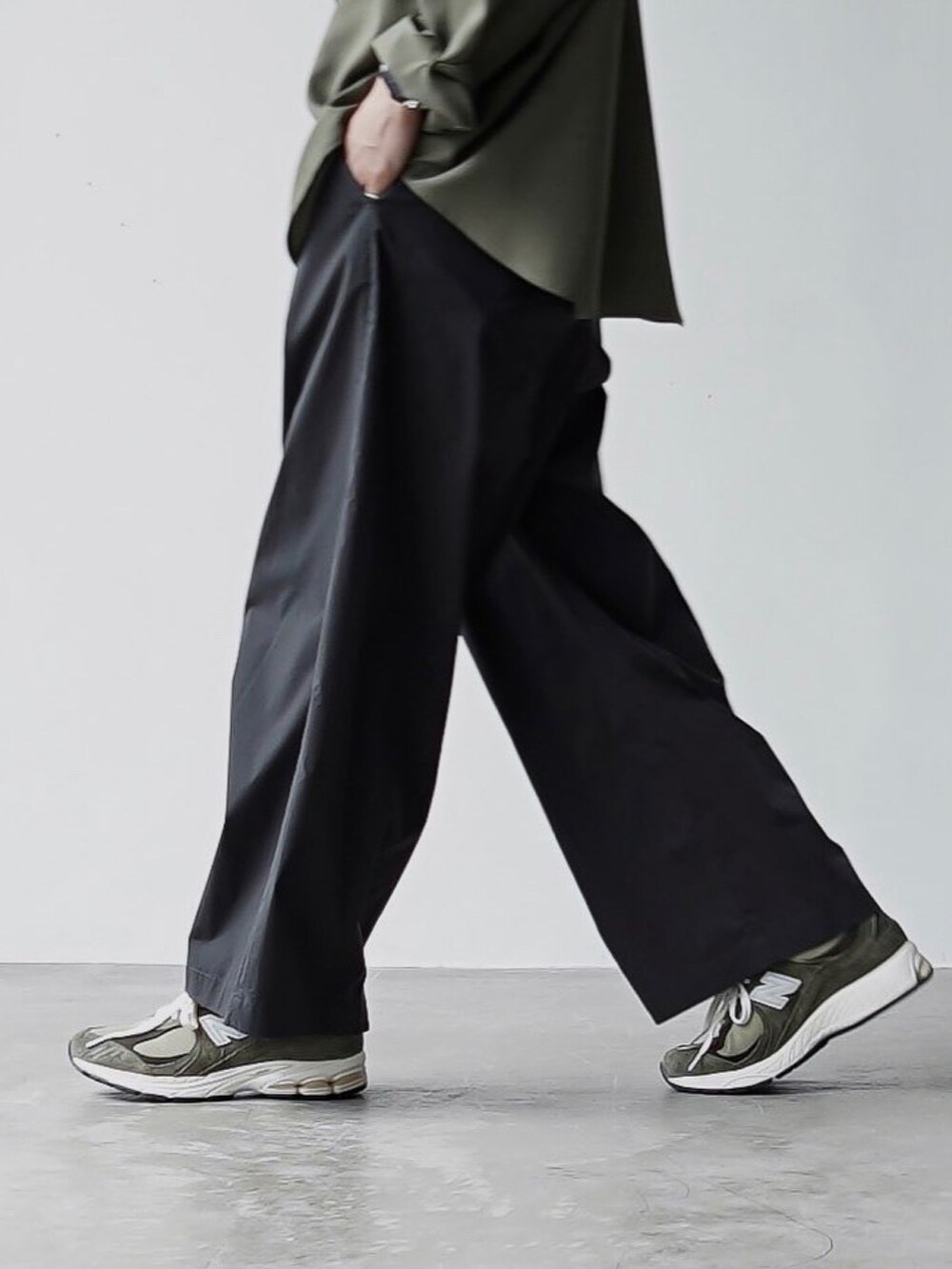 グレー系のチノパンツ、ブラック系のボディバッグ/ウエストポーチ、グリーン系のスニーカーを着用したメンズの夏コーディネートの4枚目の写真