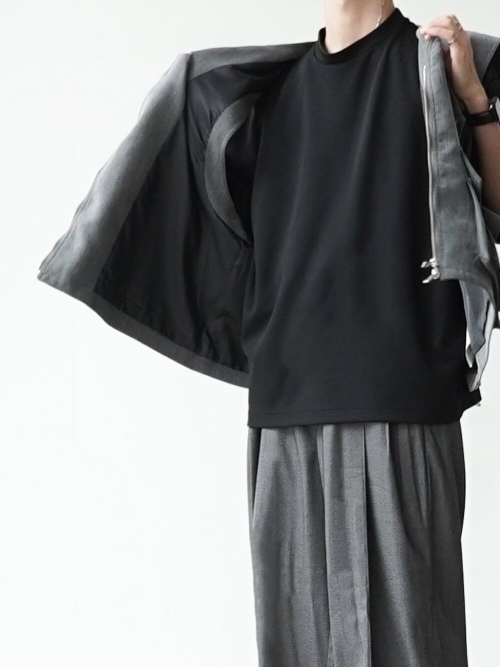 グレー系のベスト、ブラック系のTシャツ/カットソー、グレー系のスラックスを着用したメンズの夏コーディネートの3枚目の写真