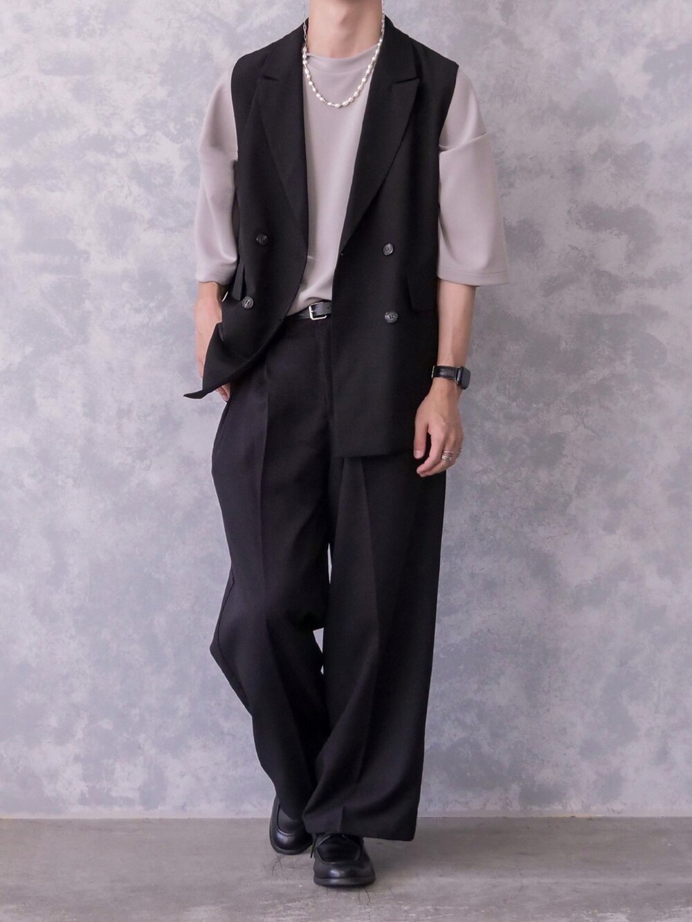 ブラック系のベスト、ブラック系のTシャツ/カットソー、ブラック系のスラックスを着用したメンズの春コーディネートの2枚目の写真