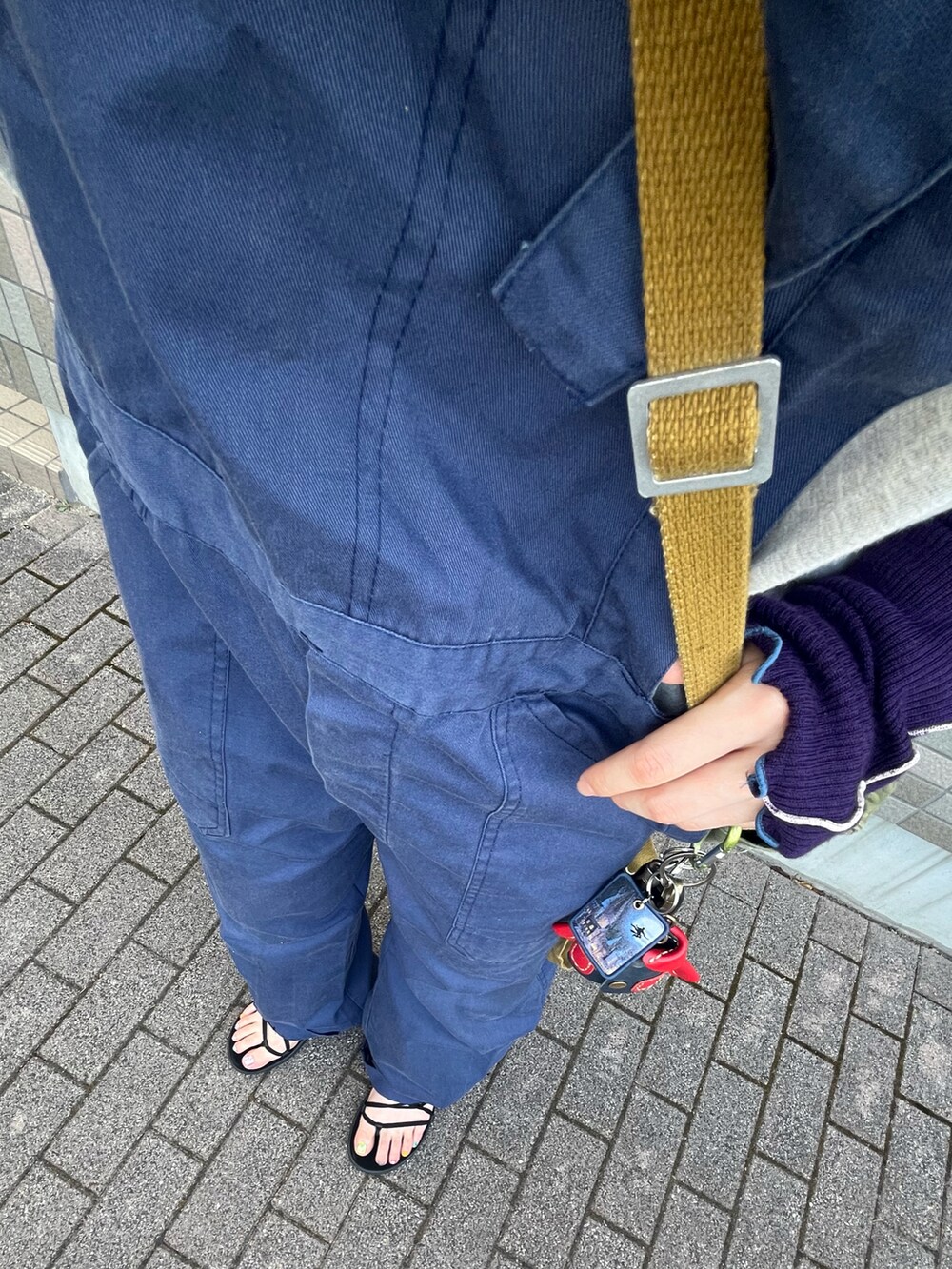 グレー系のTシャツ/カットソー、ブルー系のサロペット/オーバーオール、ブラック系のサンダルを着用したレディースの春コーディネートの2枚目の写真