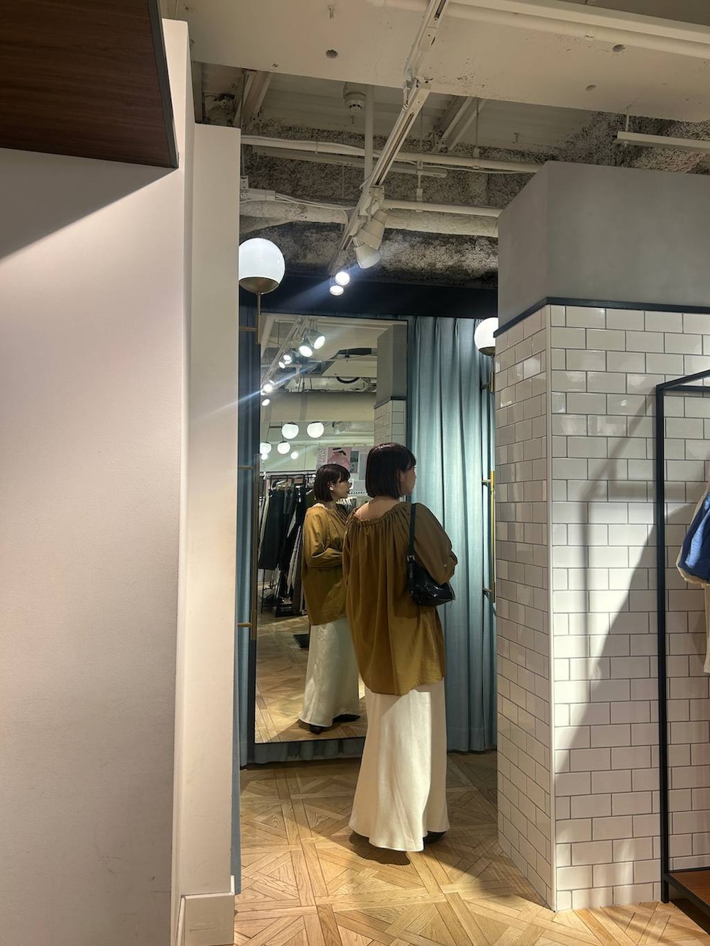 ブラック系のトートバッグ、ブラック系のパンプス、ベージュ系のシャツ/ブラウスを着用したレディースの春コーディネートの5枚目の写真