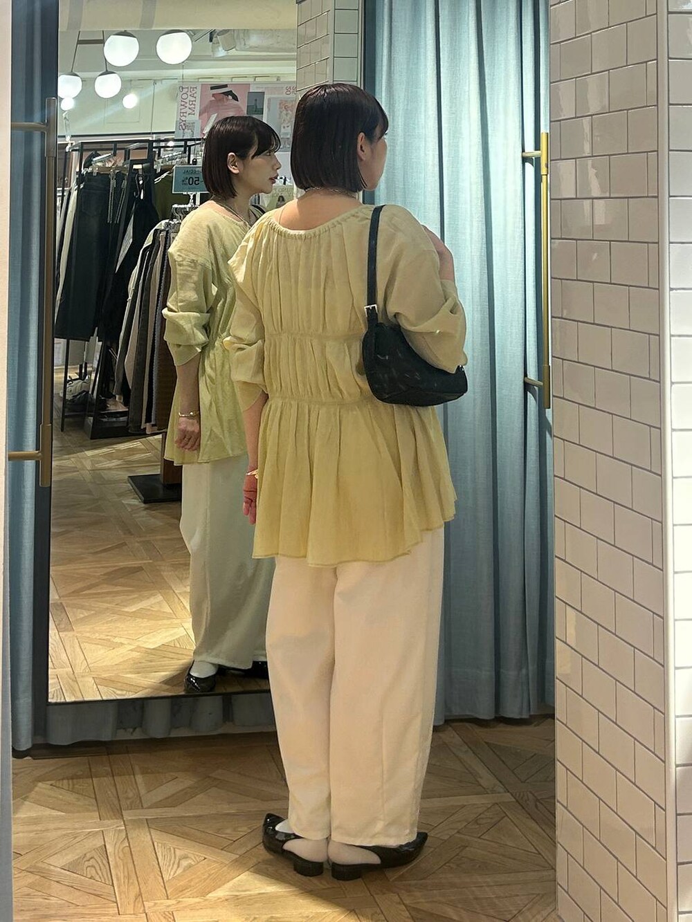 イエロー系のシャツ/ブラウス、ブラック系のトートバッグ、ブラック系のパンプスを着用したレディースの春コーディネートの2枚目の写真