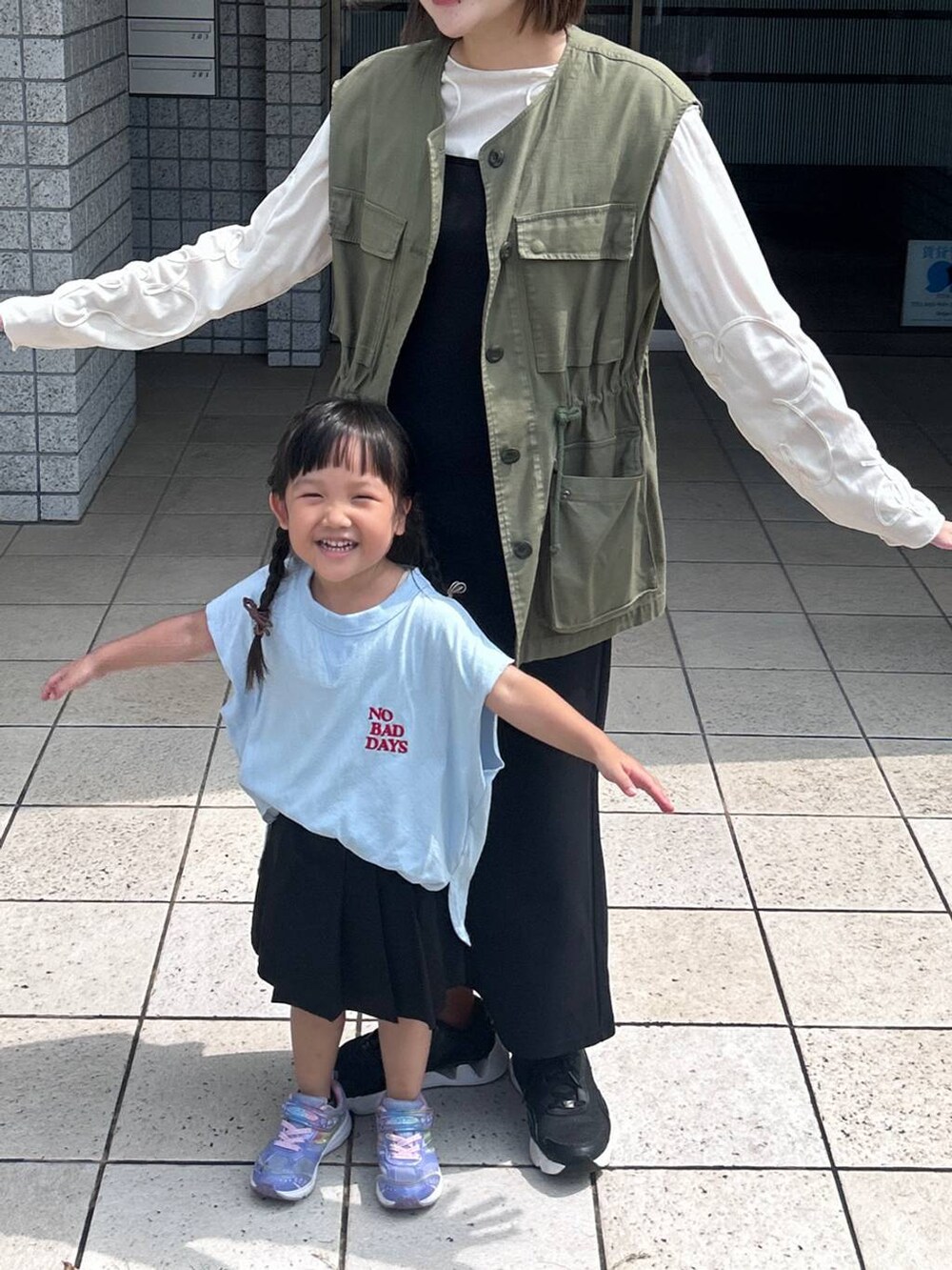 ブラック系のスカート、ブルー系のタンクトップ、ホワイト系のTシャツ/カットソーを着用したレディースの秋コーディネートの2枚目の写真