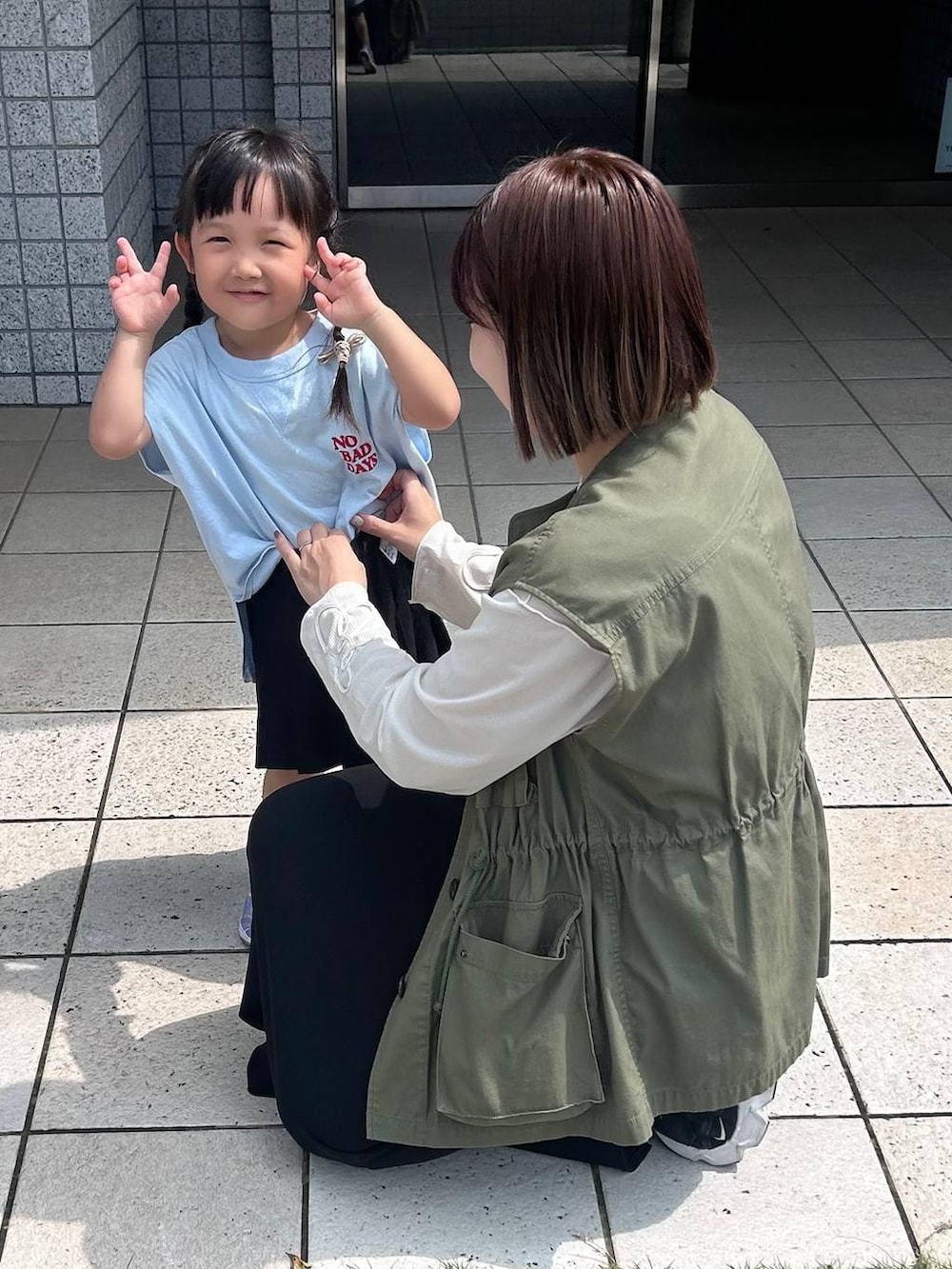 ブラック系のスカート、ブルー系のタンクトップ、ホワイト系のTシャツ/カットソーを着用したレディースの秋コーディネートの3枚目の写真